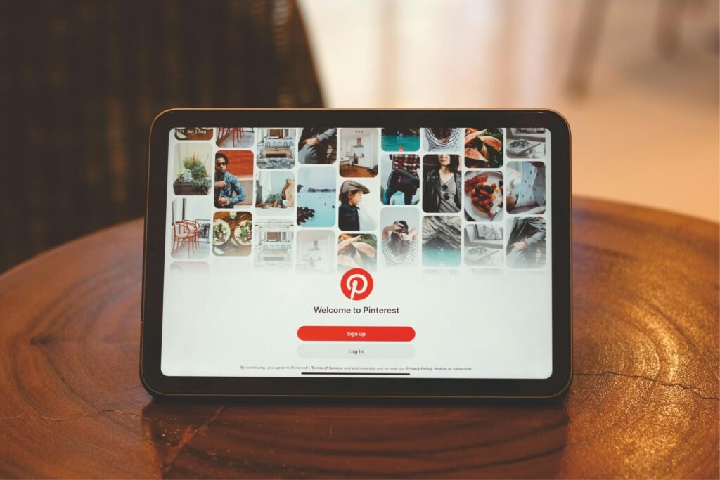 Tablet showing Pinterest login screen on a wooden table indoors.